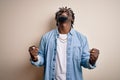 Young handsome african american man wearing casual denim shirt over white background very happy and excited doing winner gesture Royalty Free Stock Photo