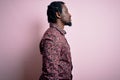 Young handsome african american man wearing casual shirt standing over pink background looking to side, relax profile pose with Royalty Free Stock Photo