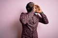 Young handsome african american man wearing casual shirt standing over pink background Shouting angry out loud with hands over Royalty Free Stock Photo