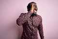 Young handsome african american man wearing casual shirt standing over pink background shouting and screaming loud to side with Royalty Free Stock Photo