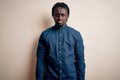 Young handsome african american man wearing casual shirt standing over white background depressed and worry for distress, crying Royalty Free Stock Photo