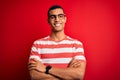 Young handsome african american man wearing casual striped t-shirt and glasses happy face smiling with crossed arms looking at the Royalty Free Stock Photo