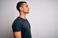 Young handsome african american man wearing casual t-shirt standing over white background looking to side, relax profile pose with Royalty Free Stock Photo