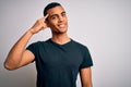 Young handsome african american man wearing casual t-shirt standing over white background Smiling pointing to head with one Royalty Free Stock Photo