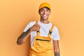 Young handsome african american man wearing handyman uniform over yellow background doing happy thumbs up gesture with hand Royalty Free Stock Photo