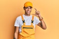 Young handsome african american man wearing handyman uniform over yellow background smiling and confident gesturing with hand Royalty Free Stock Photo