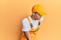 Young handsome african american man wearing handyman uniform over yellow background suffering of backache, touching back with Royalty Free Stock Photo