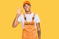 Young handsome african american man wearing handyman uniform smiling positive doing ok sign with hand and fingers Royalty Free Stock Photo