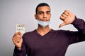 Young handsome african american man wearing medical mask holding virus alert reminder with angry face, negative sign showing Royalty Free Stock Photo