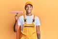 Young handsome african american man window cleaner holding glass washer looking positive and happy standing and smiling with a Royalty Free Stock Photo