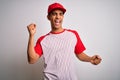 Young handsome african american sportsman wearing striped baseball t-shirt and cap Dancing happy and cheerful, smiling moving
