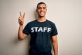 Young handsome african american worker man wearing staff uniform over white background smiling looking to the camera showing Royalty Free Stock Photo