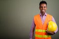 Young handsome African man construction worker against colored b Royalty Free Stock Photo