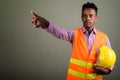 Young handsome African man construction worker against colored b Royalty Free Stock Photo