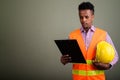 Young handsome African man construction worker against colored b Royalty Free Stock Photo