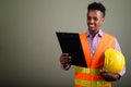 Young handsome African man construction worker against colored b Royalty Free Stock Photo