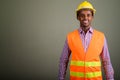 Young handsome African man construction worker against colored b Royalty Free Stock Photo