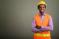 Young handsome African man construction worker against colored b Royalty Free Stock Photo