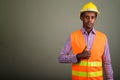 Young handsome African man construction worker against colored b Royalty Free Stock Photo