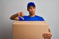 Young handsome arab delivery man holding a box standing over isolated white background with angry face, negative sign showing Royalty Free Stock Photo