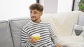 Young, handsome arab man exuding confidence enjoying his morning cup of coffee, smiling joyfully while comfortably sitting on a Royalty Free Stock Photo