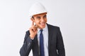 Young handsome architect man wearing suit and helmet over isolated white background smiling with hand over ear listening an Royalty Free Stock Photo