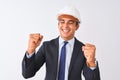 Young handsome architect man wearing suit and helmet over isolated white background very happy and excited doing winner gesture Royalty Free Stock Photo