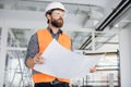 Young handsome arhitect posing indoors with building drawings