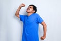 Asian boy wearing white tshirt standing over white background stretching back, tired and relaxed, sleepy and yawning for early