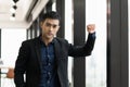 Young handsome asian businessman in suit standing near window in office. Royalty Free Stock Photo