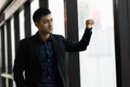 Young handsome asian businessman in suit standing near window in office Royalty Free Stock Photo