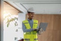 Young handsome asian engineer holding laptop looking forward and thinking, planning on construction building Evolution Royalty Free Stock Photo