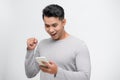 Young handsome Asian man being surprised after reading message from smarrtphone studio short isolated Royalty Free Stock Photo