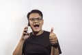 Young handsome Asian man calling by smartphone with happy expression agreeing on white background