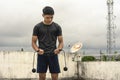 A young handsome asian man holding a cordless jumping ropes outside a floor deck. Cardio training exercise regimen