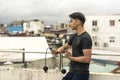 A young handsome asian man holding a cordless jumping ropes outside a floor deck. Cardio training exercise regimen