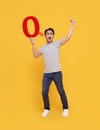 Young handsome Asian man holding up to 0% and happy celebrating on yellow background for no interest installment payment concept