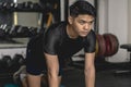 A young handsome asian man mentally prepares before starting a set of Bird-Dogs on a mat at the gym. Doing simple core exercises