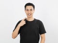 Young handsome asian man smiling with braces and looking at camera with finger pointing isolated on white background. Royalty Free Stock Photo