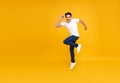 Young handsome Asian man smiling and jumping while celebrating success isolated over yellow background. Royalty Free Stock Photo