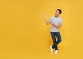 Young handsome Asian man standing with his finger pointing isolated on yellow background with copy space. panoramic background Royalty Free Stock Photo