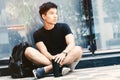 Young handsome asian men wearing casual black tshirt and backpack at day in Sai Gon city, Vietnam