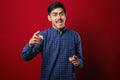 Young handsome asian man wearing casual shirt pointing to you and the camera with fingers, smiling positive and cheerful Royalty Free Stock Photo