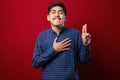 Young handsome asian man wearing casual shirt smiling swearing with hand on chest and fingers up, making a loyalty promise oath Royalty Free Stock Photo