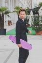 Young handsome Asian model posing with his skateboard Royalty Free Stock Photo