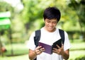 Young handsome Asian student with books and smile in outdoor Royalty Free Stock Photo