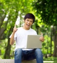 Young handsome Asian student with laptop Royalty Free Stock Photo