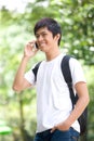 Young handsome Asian student talking on cell phone Royalty Free Stock Photo
