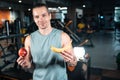 young handsome athlete hungry and eating healthy apple fruit in gym Royalty Free Stock Photo