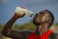 Young handsome and attractive black African American sport man tired and thirsty after running workout holding bottle drinking Royalty Free Stock Photo